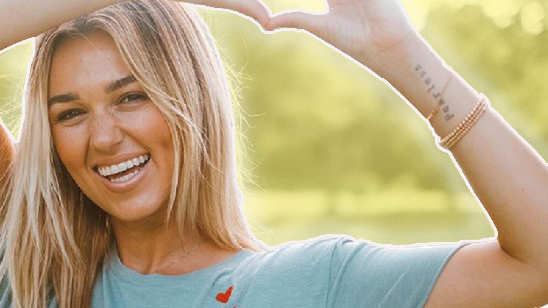 Sadie Robertson Poses for a Photo Making a Heart with her hands.